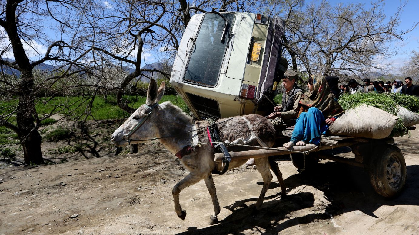 Children in Kabul, Afghanistan, ride a donkey cart past the site of a roadside bomb explosion on Monday, April 11. An Afghan official said at least one person was killed when a bomb ripped through a bus carrying employees of the Education Ministry.