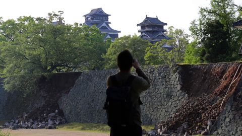 A man takes a picture of a damaged stone wall at Kumamoto Castle, in the city of Kumamoto, on April 15.