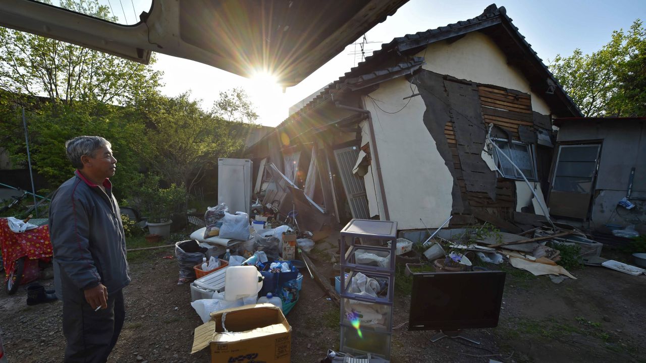 A man stands in front of his collapsed house in Mashiki on April 15.