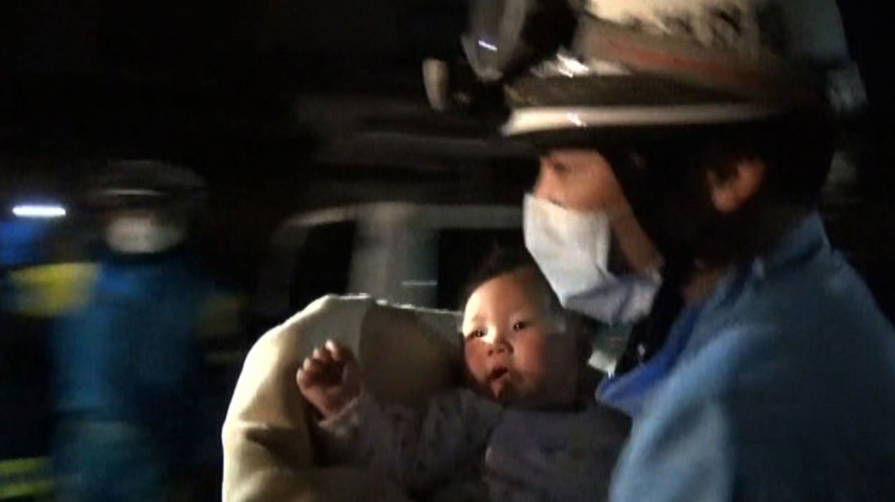 A rescue worker carries an 8-month-old girl after she was pulled from rubble in Mashiki on April 15.