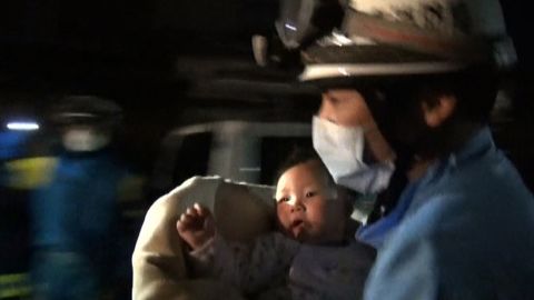 A rescue worker carries an eight-month-old baby girl after she was pulled from the rubble following the earthquake in Mashiki, Kumamoto Prefecture. 