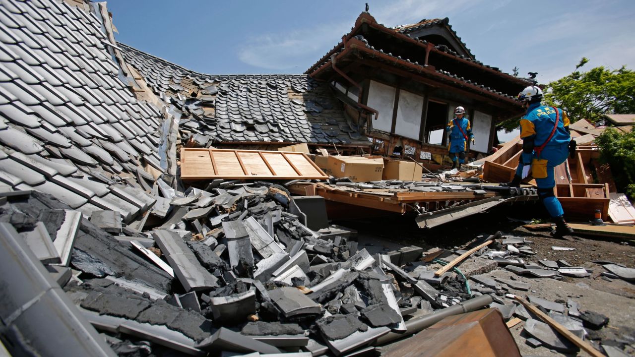 A police rescue team searches a damaged house for earthquake survivors Friday, April 15, in Mashiki, Japan. 
