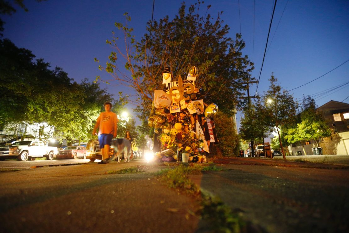 People walk past a makeshift memorial near the Will Smith was killed. 