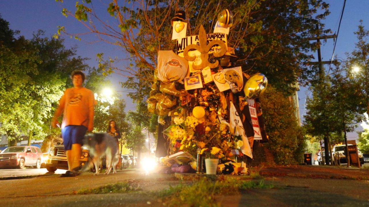 People walk past a makeshift memorial near the Will Smith was killed. 