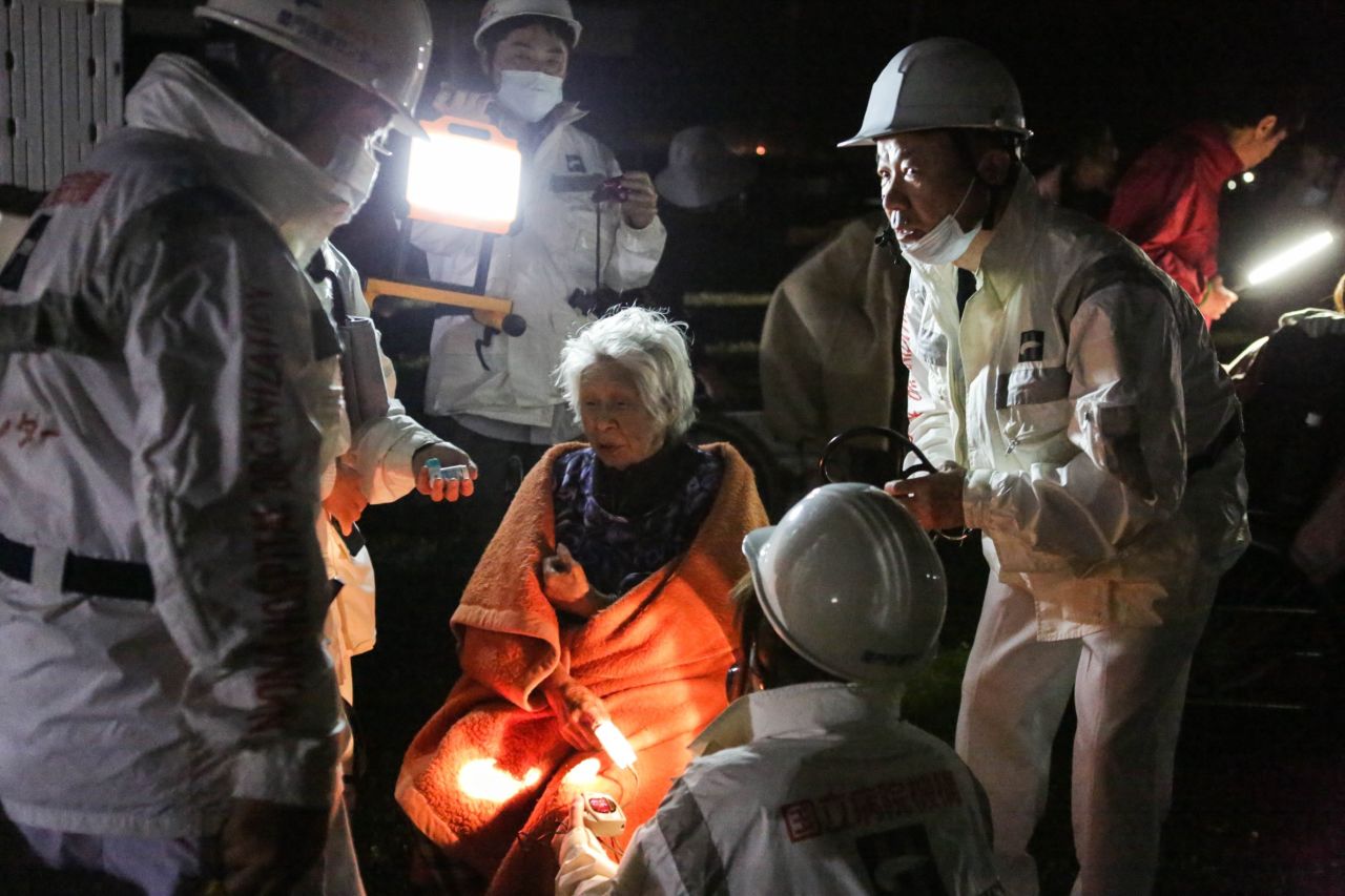 Rescue workers take care of a woman suffering from shock  at the evacuation center at the Mashiki Town Gymnasium on Saturday, April 16, in Kumamoto, Japan. 