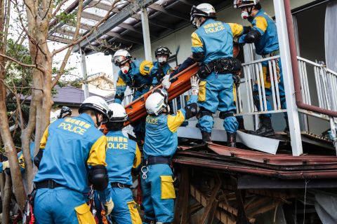 A rescue team removes a man from his damaged house house on April 16 in Kumamoto. 