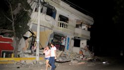 Residents walk on a street amid destroyed buildings on April 16, in Guayaquil, Ecuador.