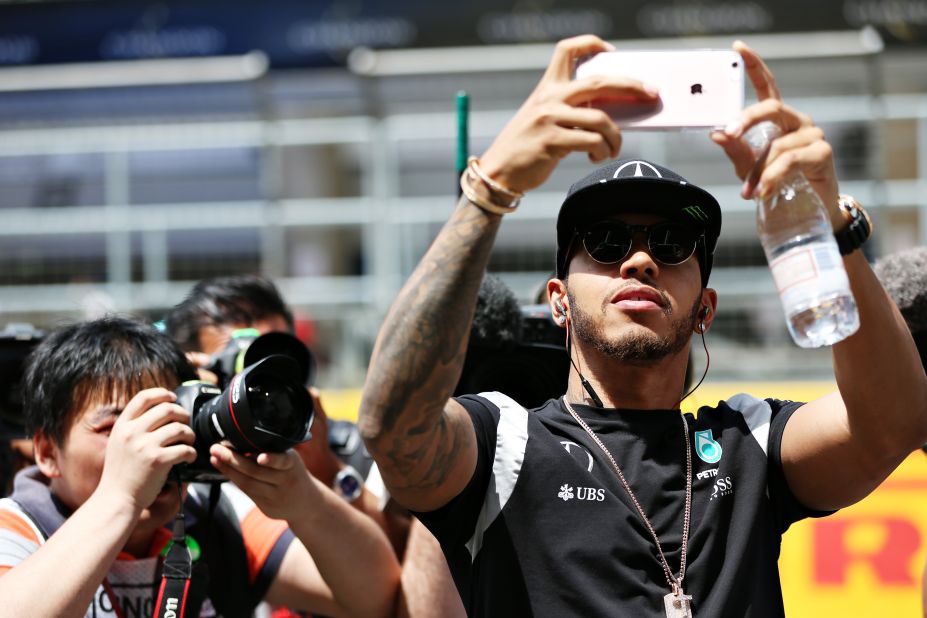 Lewis Hamilton of Great Britain and Mercedes GP takes a photo of the crowd on his way to the drivers parade ahead of the Formula One Grand Prix of China at Shanghai International Circuit on April 17, 2016 in Shanghai, China. 