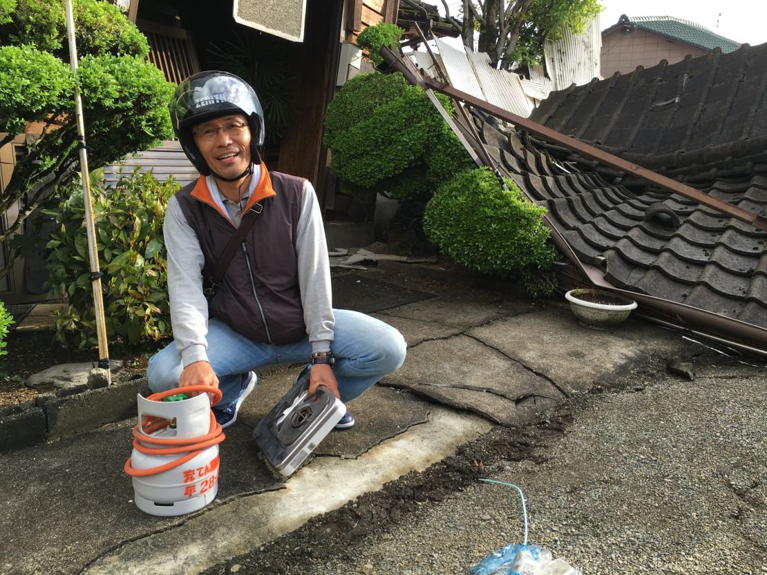 Yoshitada Shimamura holding a gas canister recovered from his destroyed home. 