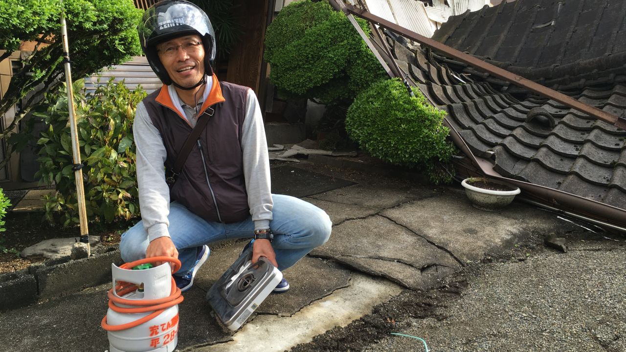 Yoshitada Shimamura holding a gas canister recovered from his destroyed home. 