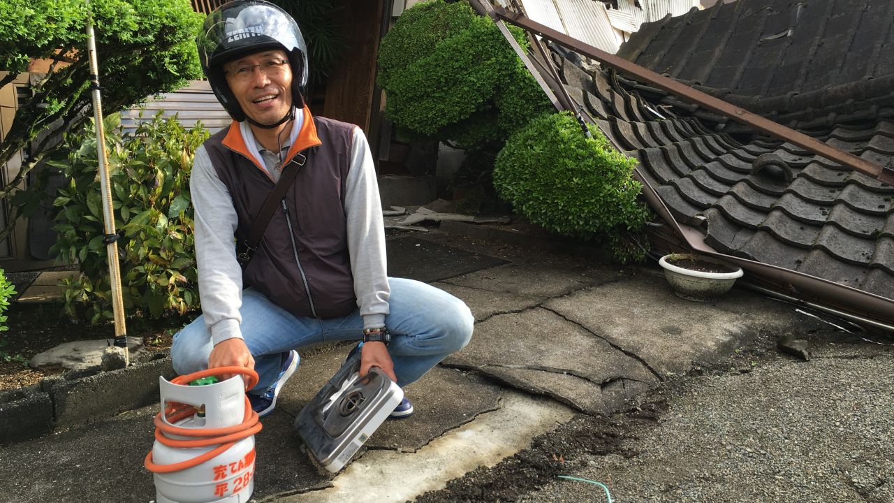 Yoshitada Shimamura holding a gas canister recovered from his destroyed home.