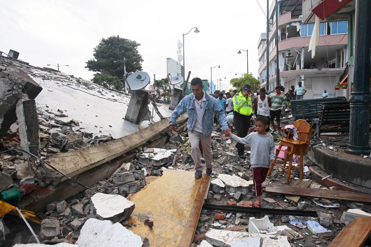People make their way through debris from a collapsed building in Pedernales, Ecuador, on April 17.