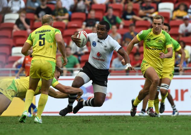 Fiji's Kitione Taliga (C) runs past Australian players during their Cup quarter-final match at the Singapore Sevens rugby tournament on April 17, 2016. 