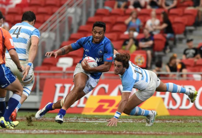 Samoa's Tomasi Alosio (C) runs past Argentina during their Cup quarter-final match at the Singapore Sevens rugby tournament on April 17, 2016.