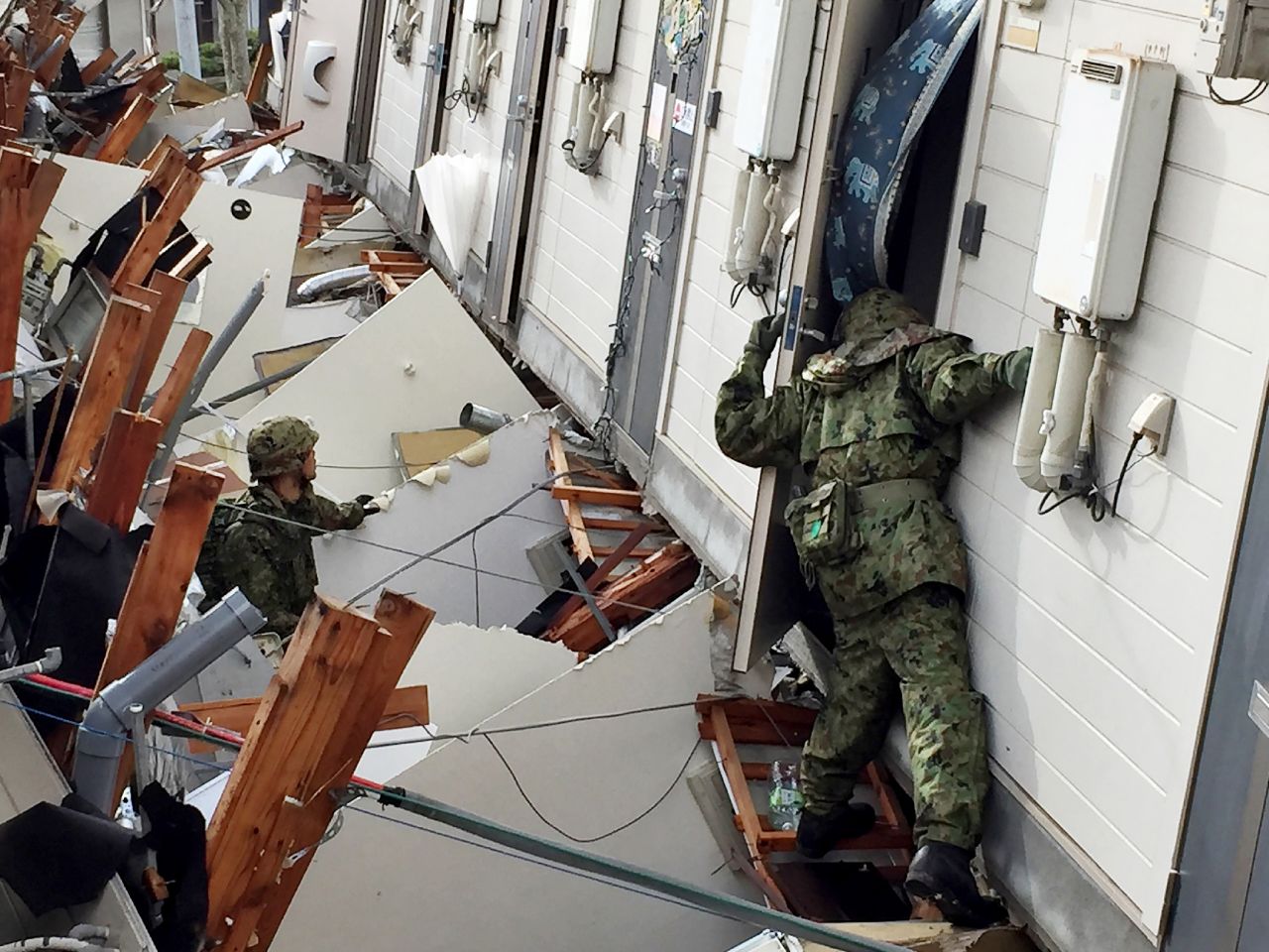 Soldiers search for survivors at a collapsed apartment in Minamiaso on April 17.