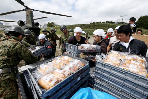 Students and soldiers unload food from helicopters  at the isolated Tokai University campus on April 17.