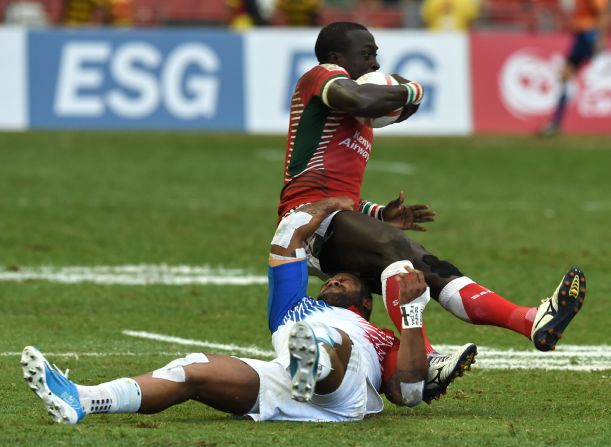 France's Virimi Vakatawa (bottom) tackles Kenya's Collins Injera (top) during their cup quarter-final match at the Singapore Sevens rugby tournament on April 17, 2016.