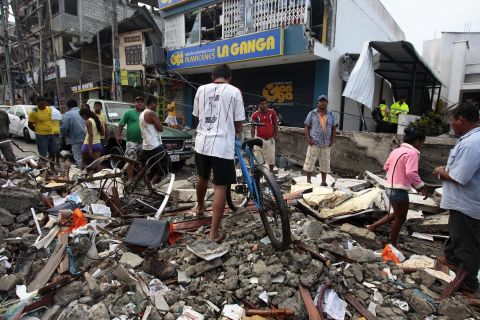 People walk among the debris of a collapsed building in Pedernales, Ecuador, on April 17. 