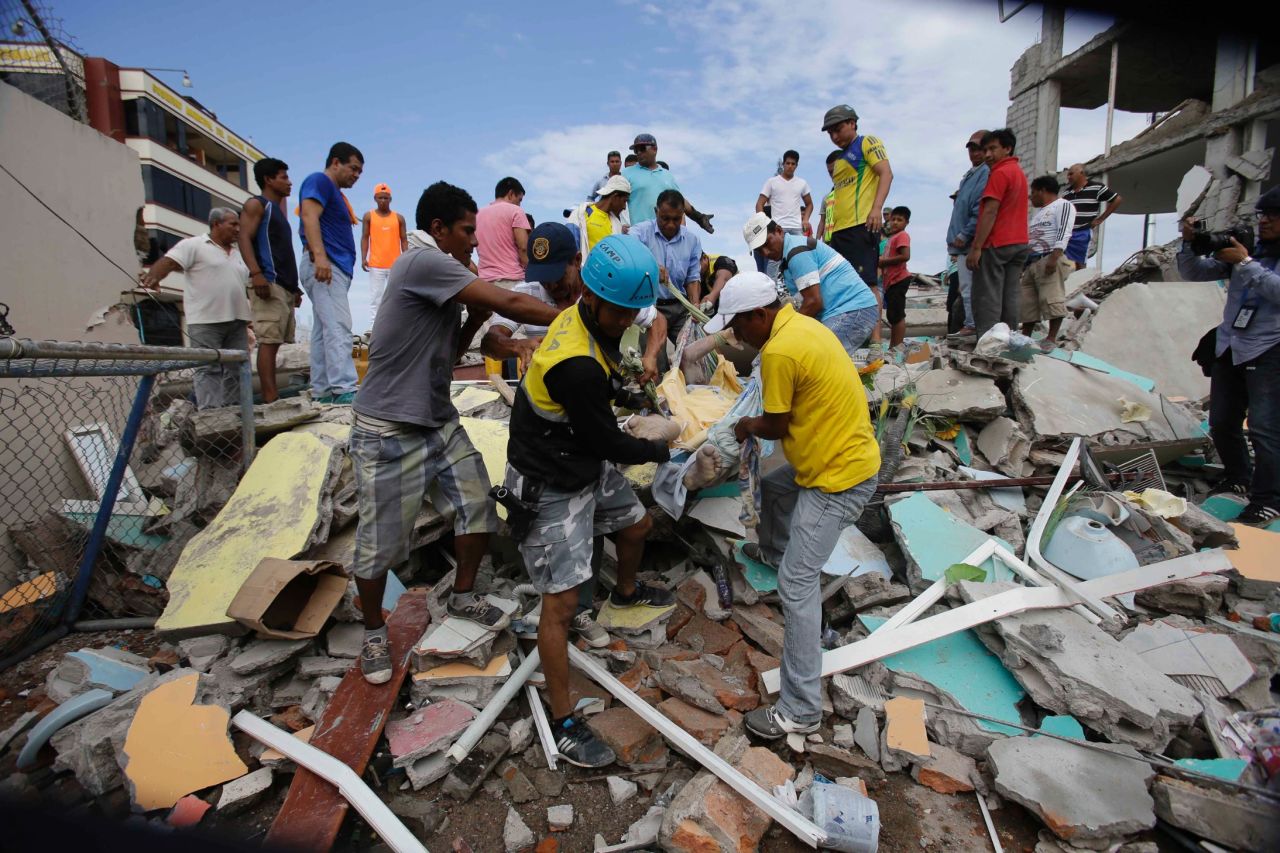 Volunteers remove a body from a destroyed house in Pedernales, Ecuador, on April 17.
