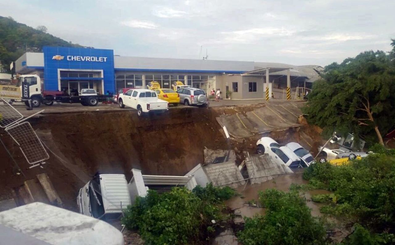 Vehicles from a car dealership hang on a precipice caused by an earthquake induced landslide in Portoviejo, Ecuador, on April 17.