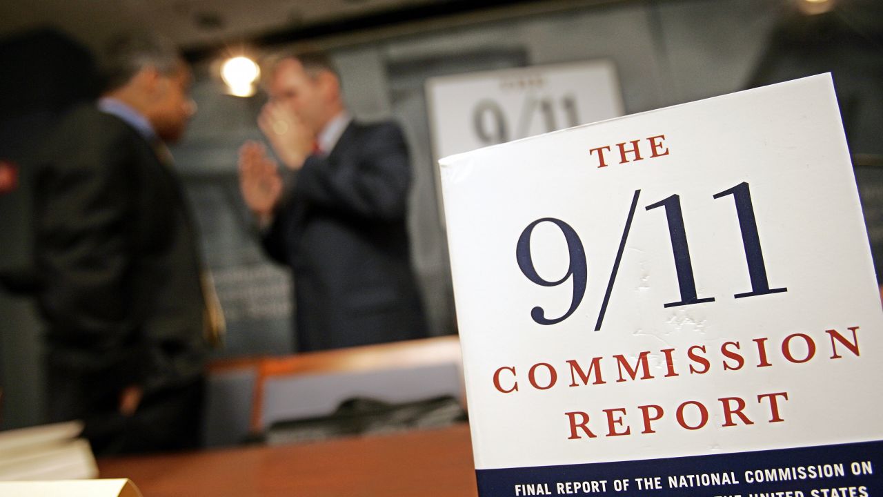The 9/11 Commission Report stands on display as specialists in government and security talk in the background before a discussion June 28, 2005 in Washington. Members of the 9/11 Public Discourse Project held the event to discuss securing the US. The group discussed how far the US has come in improving border security, transportation security and emergency preparedness since the September 11, 2001 terrorist attacks.