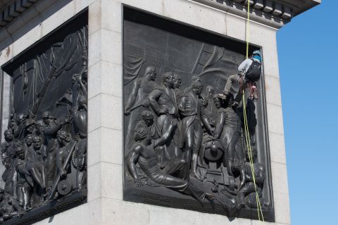 A Greenpeace activist abseils down Nelson's Column statue in Trafalgar Square, central London, after attaching a breathing mask to it on April 18, 2016. 