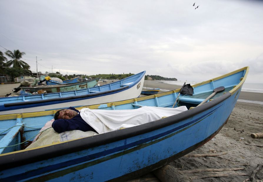 A man, his home destroyed by the earthquake, sleeps in a boat docked along the shore in La Chorrera on April 18.