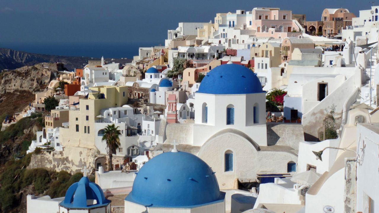 The Greek island of Santorini, the remains of an exploded volcano in the Aegean Sea, has black sand beaches and picturesque villages. 