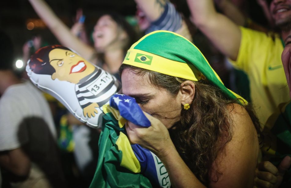 A pro-impeachment supporter kisses a Brazilian flag while watching a live television broadcast moments after lower house deputies vote to approve the motion to continue the impeachment process.