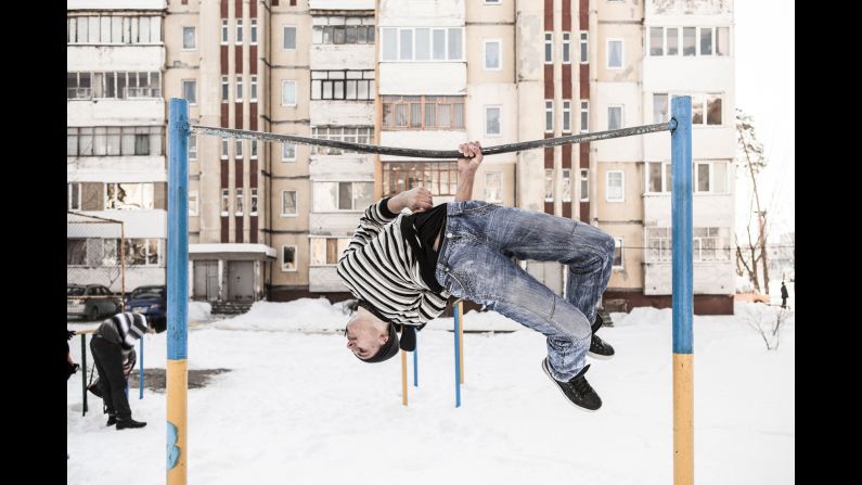 A young man performs acrobatics on a fixed bar at a playground in Slavutych. There aren't many career options in the area and there's not much to keep young people entertained, Ackermann said.