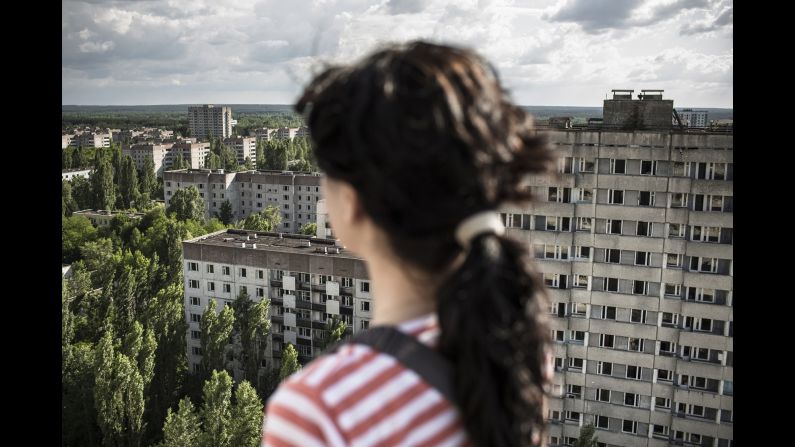 A young woman looks out at the ghost town of Pripyat.