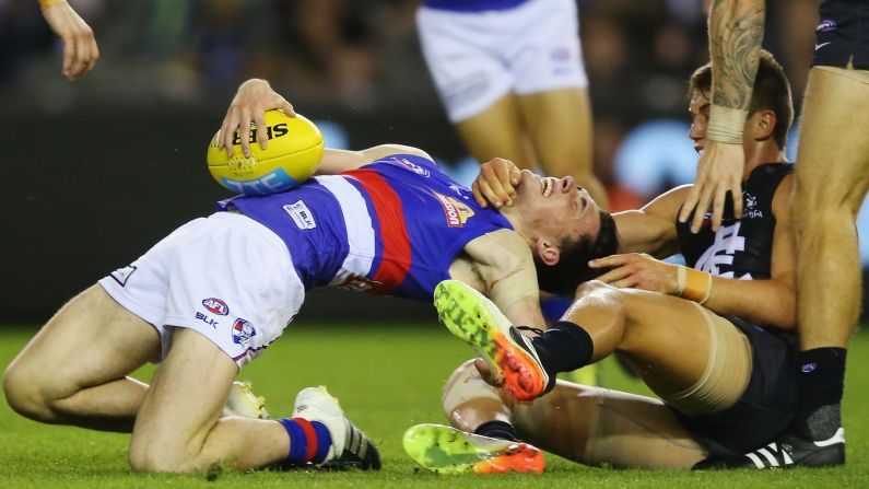 Toby McLean, left, is tackled by the throat by Patrick Cripps during an AFL Round 4 match between the Carlton Blues and the Western Bulldogs at Etihad Stadium in Melbourne, Australia, on April 16.