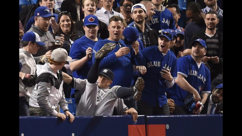 New York Yankees' Brett Gardner falls into the stands after catching a foul ball hit by Toronto Blue Jays' Ryan Goins during the third inning on Thursday, April 14, in Toronto. 