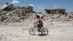 TAL ABYAD, SYRIA - JUNE 20: (TURKEY OUT) A boy rides his cycles in the streets of the destroyed Syrian town of Kobane, also known as Ain al-Arab, Syria. June 20, 2015. Kurdish fighters with the YPG took full control of Kobane and strategic city of Tal Abyad, dealing a major blow to the Islamic State group's ability to wage war in Syria. Mopping up operations have started to make the town safe for the return of residents from Turkey, after more than a year of Islamic State militants holding control of the town. (Photo by Ahmet Sik/Getty Images)