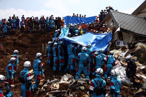 Rescuers prepare to remove the body of a woman found in a house destroyed by a mudslide in Minamiaso on Tuesday, April 19, in the aftermath of a 7.0-magnitude quake on Kyushu Island. The same region was hit by a <a href="http://www.cnn.com/2016/04/14/asia/japan-earthquake/" target="_blank">6.2-magnitude quake</a> on Thursday, April 14. 