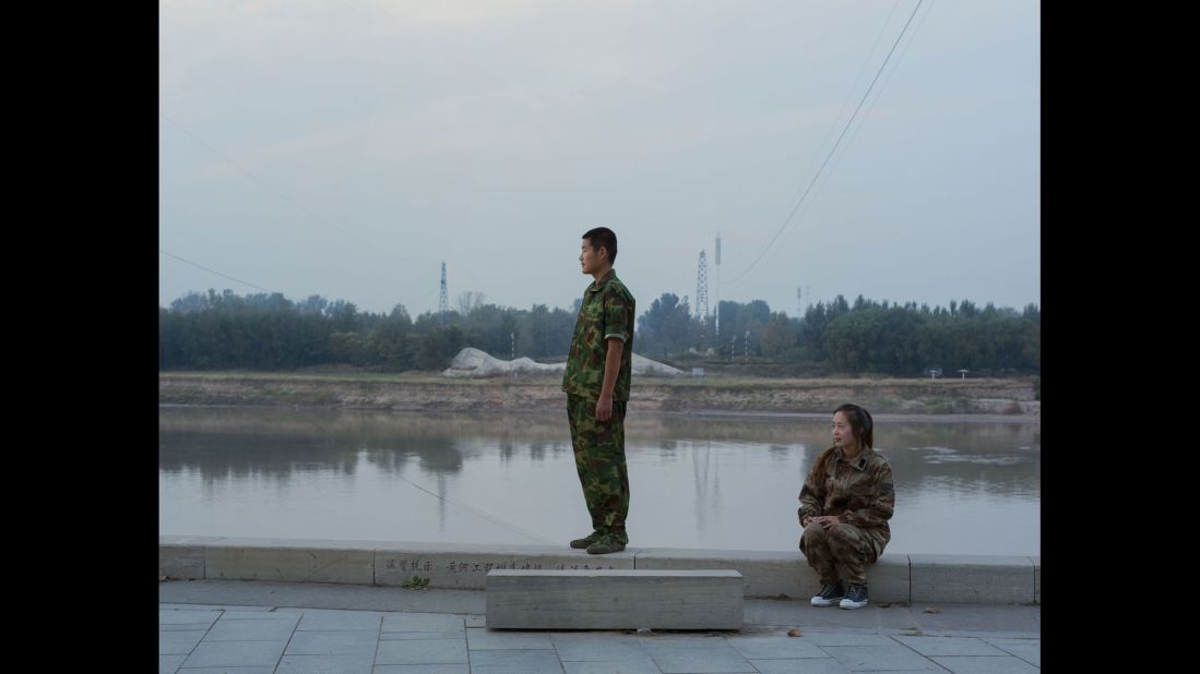A boy stands near teacher Zhang Dan Dan during training at the Yellow River.