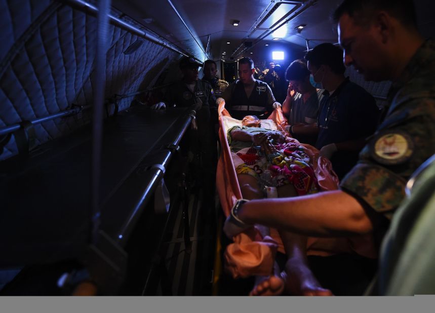 Soldiers move an injured person onto a military airplane at an air base in Manta on Tuesday, April 19. A magnitude-7.8 quake struck off Ecuador's central coast on Saturday, April 16, flattening buildings and buckling highways. It's the deadliest quake to strike the South American country in decades. 