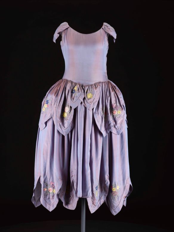 In the 1920s, Jeanne Lanvin became known for her <em>robe de style</em> with its full pannier hips, and her trademark use of intricate trimming and embroideries in light floral colors. <br /><br />In an example of successful brand marketing, the illustrator Paul Iribe sketched Jeanne and her daughter both wearing a dress in this style, and the image has been used as the logo for the house since 1927.  <br /><br />We acquired this dress recently from a vintage haute couture specialist in London to enable us to tell this story.  It offers an eye-catching contrast to the androgynous flapper style that we usually associate with the decade.