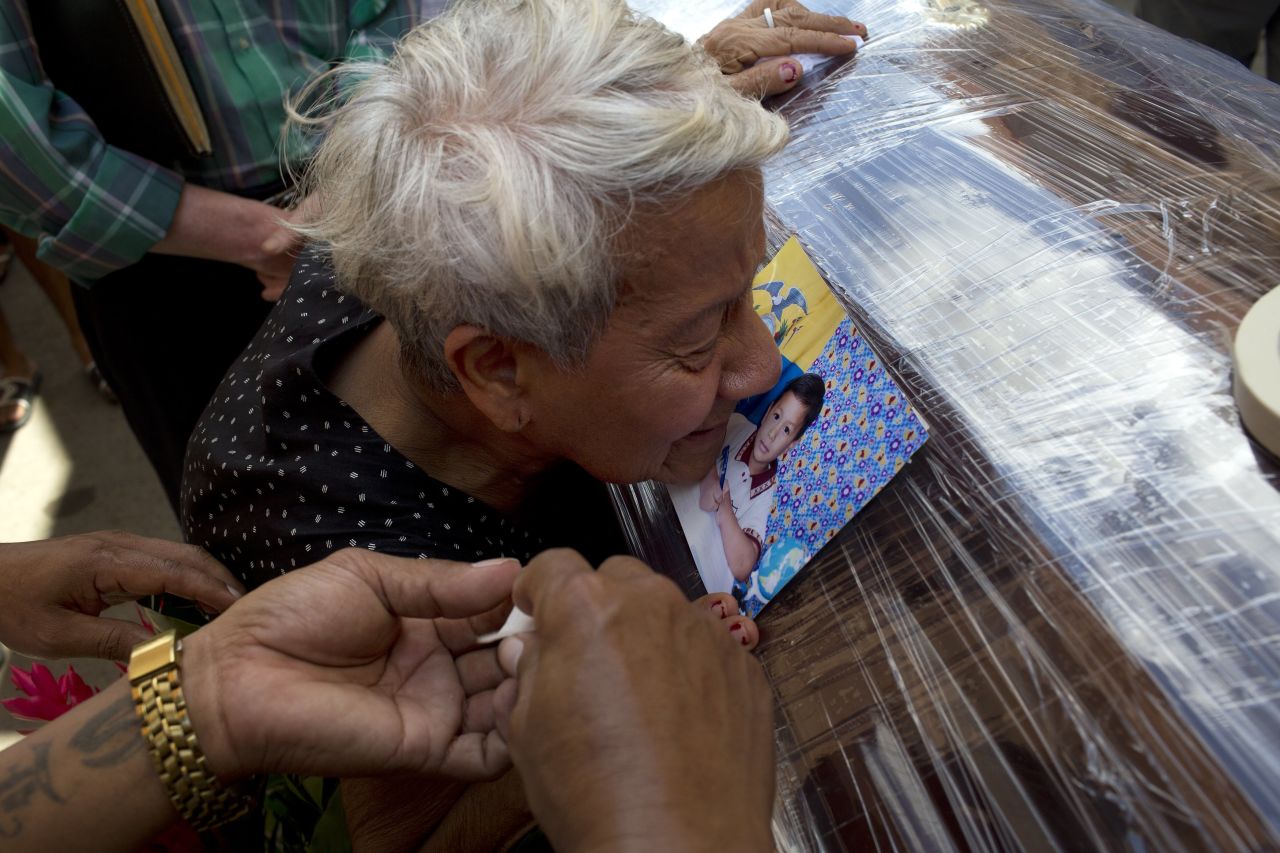 A relative kisses a photo of Kexly Valentino attached to her coffin in Montecristi on April 19. Kexly and her mother and brother died in the quake.