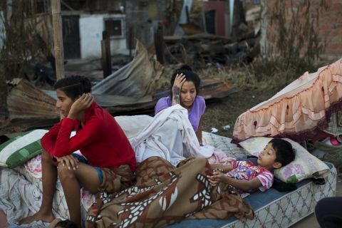 A Manta family wakes up April 19 after sleeping outside their home destroyed in the quake.