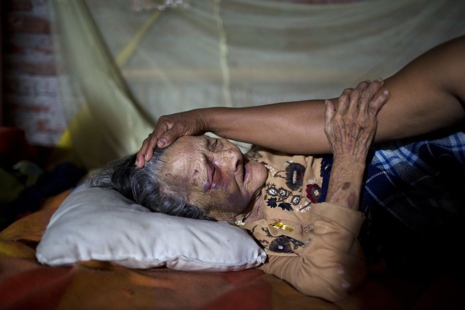 Maria Victoria, 89, is comforted by her daughter Mariana in Estancia Las Palmas on April 19. The elderly woman was injured when a column fell on her. 