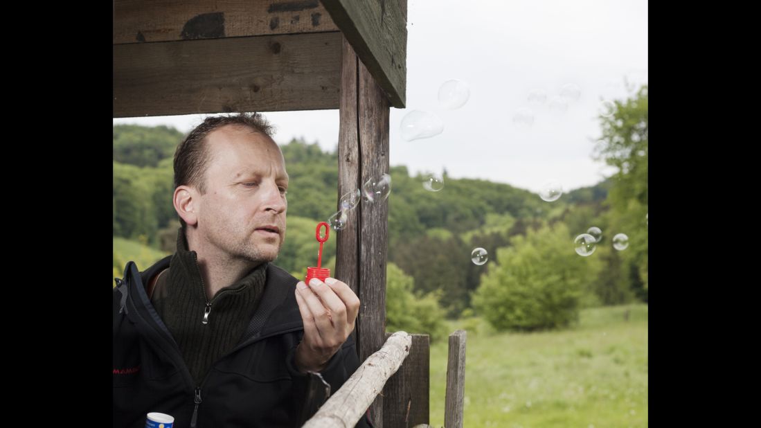 Jens Stormer, a hunter, blows soap bubbles to see which way the wind is going. This way, animals can't detect him.