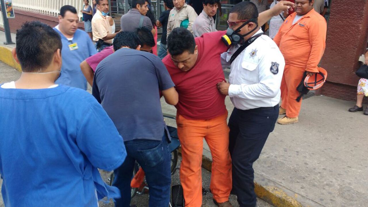 A worker receives help while being admitted to the hospital in Coatzacoalcos.