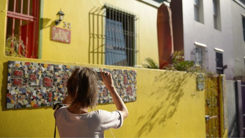 A woman takes an audio tour around Bo-Kaap, guided by a local via VoiceMap. 