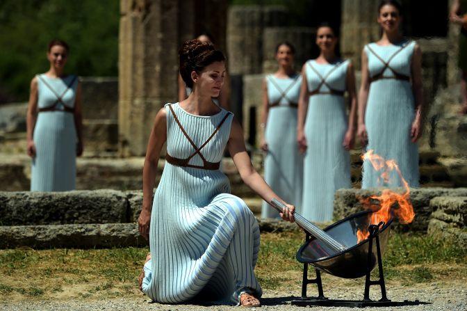 The Olympic flame is back: Greek actress Katerina Lechou performs the role of the high priestess as she lights the Olympic flame at the Temple of Hera at the site of ancient Olympia.
