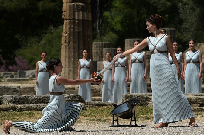 Lechou passes the Olympic flame into a small ceramic bowl. The ceremony was performed at the site where the Olympics were born in 776 BC and remained for 12 centuries.