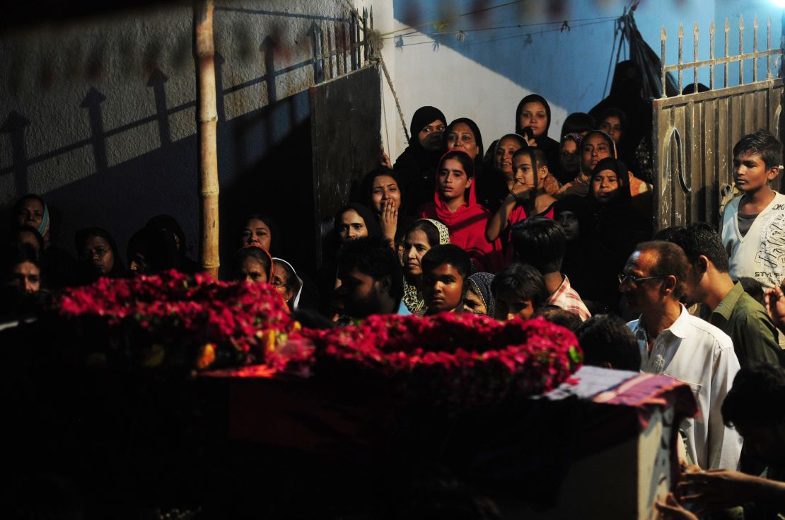 Pakistani relatives look at the coffin of a policeman who was killed with other colleagues in an attack by gunmen during his funeral in Karachi on April 20, 2016.

