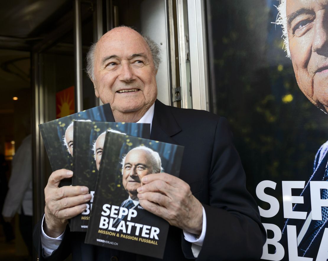FIFA's ex-president Sepp Blatter poses with a copy of his biography.