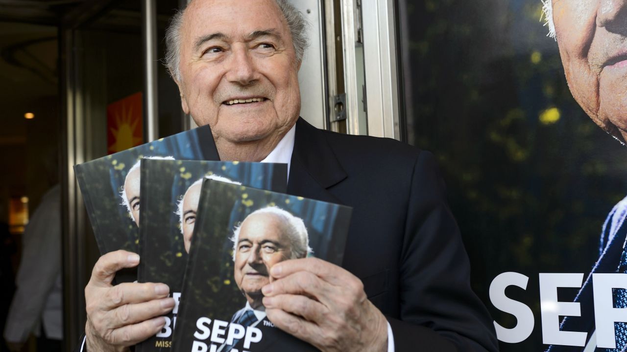 FIFA's ex-president Sepp Blatter poses with a copy of his biography.