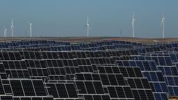 EL BONILLO, SPAIN - DECEMBER 02:  Photovoltaic power panels stand at Abaste's El Bonillo Solar Plant while wind turbines spin at a wind farm on the background on December 2, 2015 in El Bonillo, Albacete province, Spain. Spain in 2008 was a leading country on photovoltaic power and renewable energies but after some law changes the solar power industry collapsed, with companies either closing or turning to overseas markets. The UN Climate Change Summit is taking place in Paris over two weeks, in an attempt to agree on an international deal to curb greenhouse gas emissions.  (Photo by Pablo Blazquez Dominguez/Getty Images)
